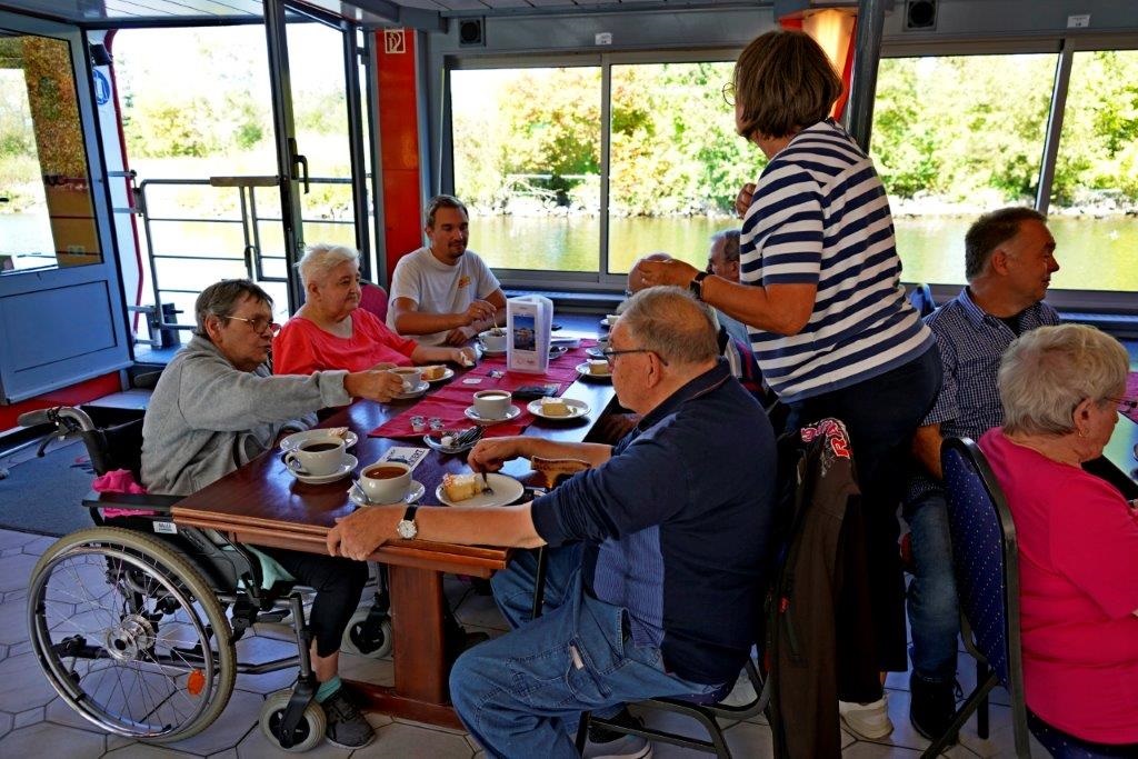 Rollstuhlfahrer beim Kaffeetringen während der Mainschifffahrt