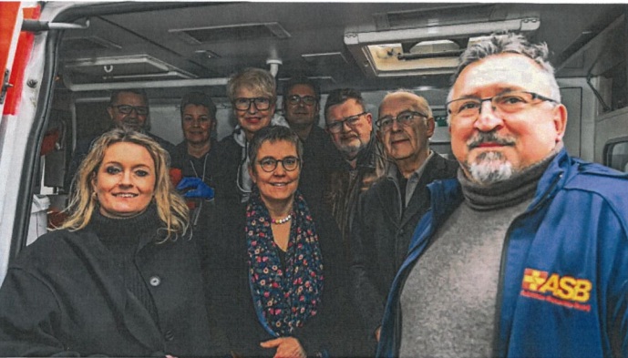 Gruppe mit Geschäftsführer im Ambulanzbus